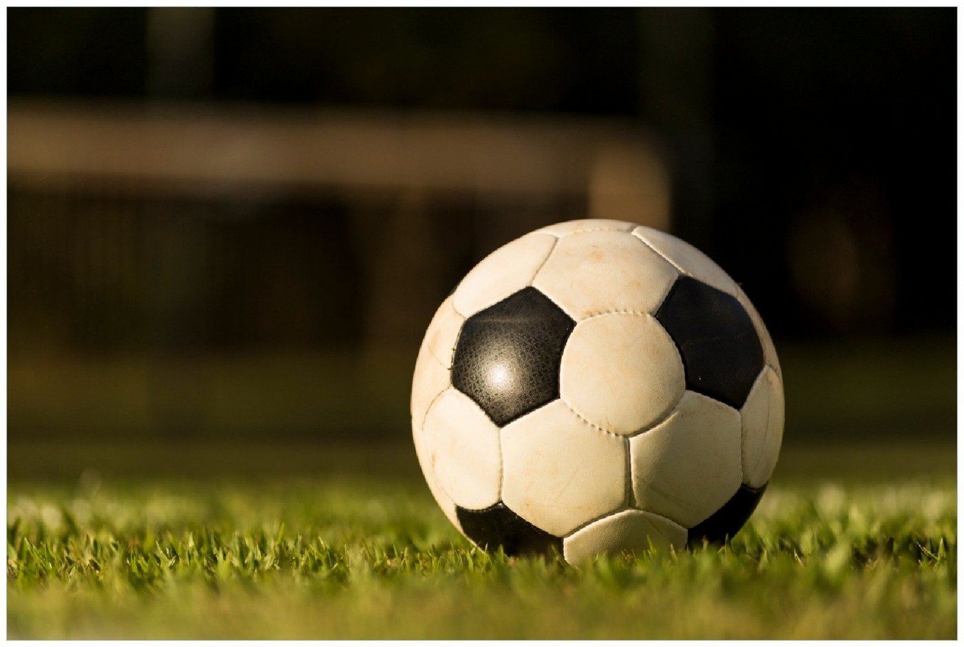 Wallario Poster, Fußball - sonnenbeleuchtet auf dem Feld, in verschiedenen Ausführungen von Wallario